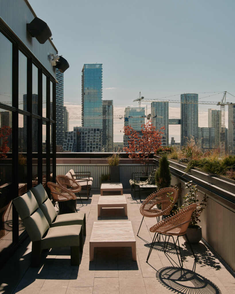 Evangeline Rooftop | Golden hour shot of the rooftop patio with seating and city views | Homes Almanac