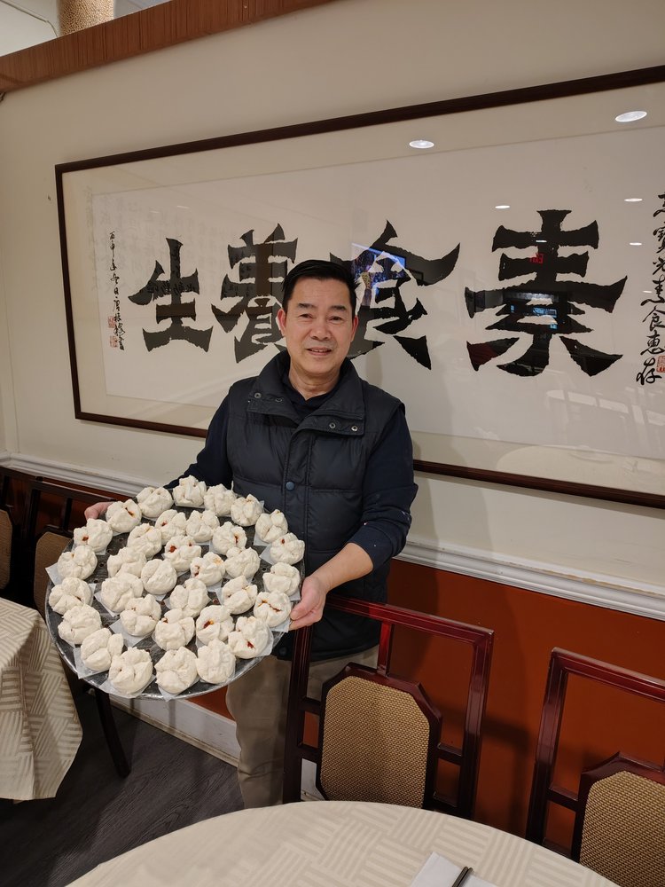 Sun Bo Kong Vancouver | Photo of man holding a plate of BBQ pork buns | Homes Almanac