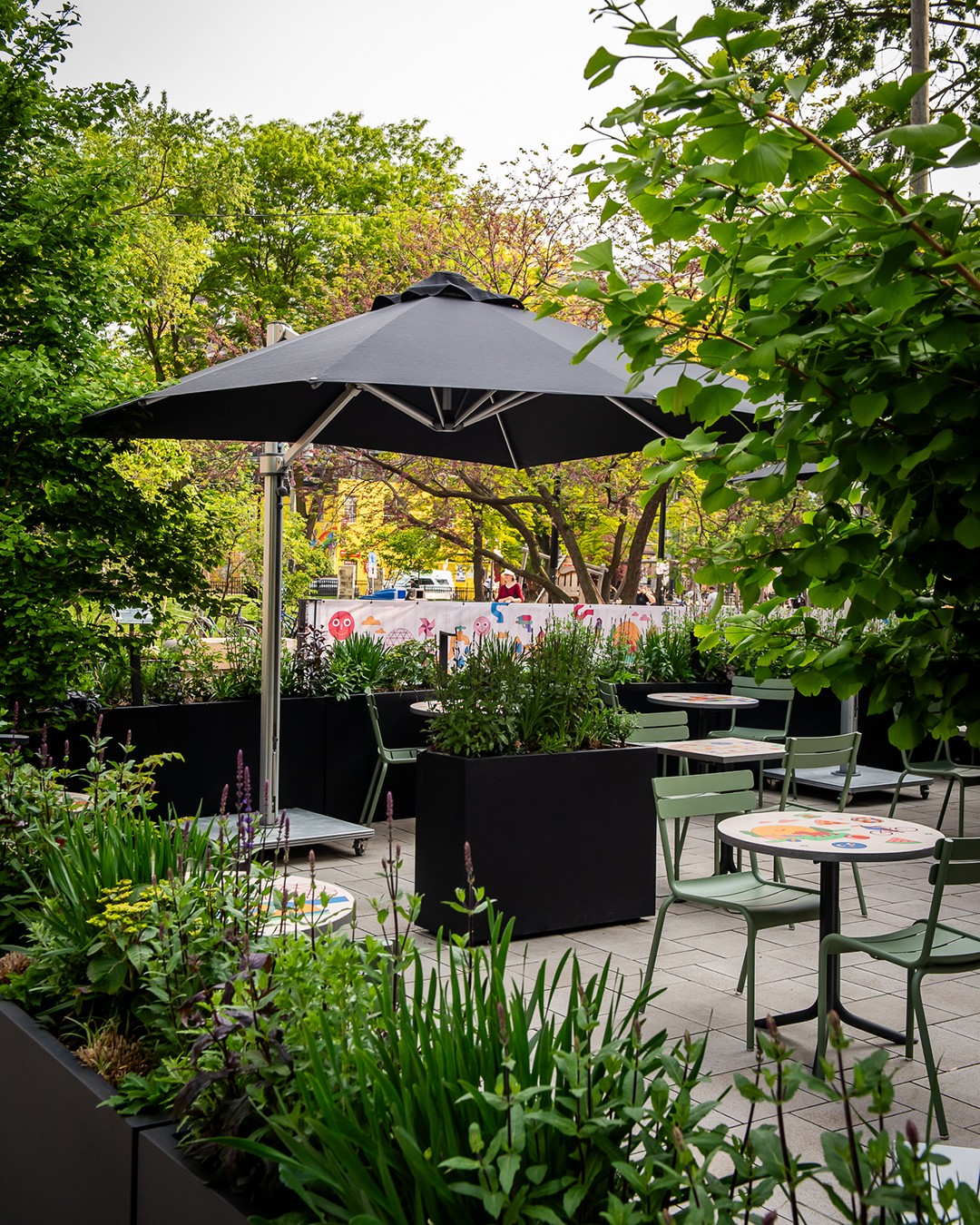 Civil Parks by Civil Works | Lush outdoor patio with a black umbrella and seating | Homes Almanac