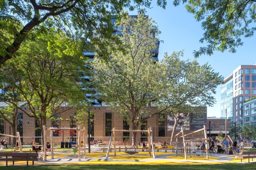 Historic Downtown Toronto Park | Bright daylight over the park with children's playground and the Waterworks Food Hall building in the background and mature trees | Homes Almanac