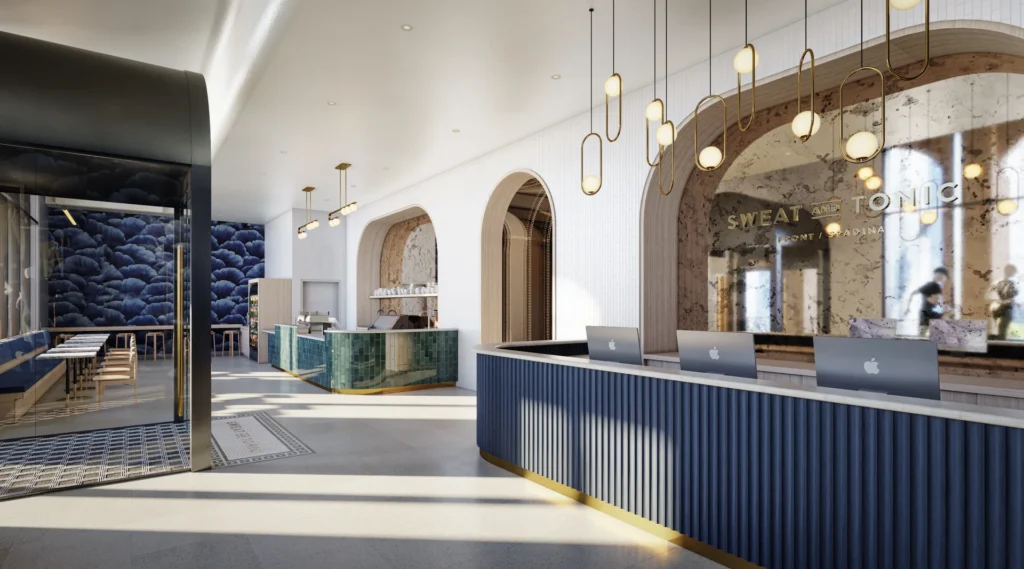Sweat and Tonic at The Well | Bright foyer with white marble floors and walls with a blue front desk | Homes Almanac