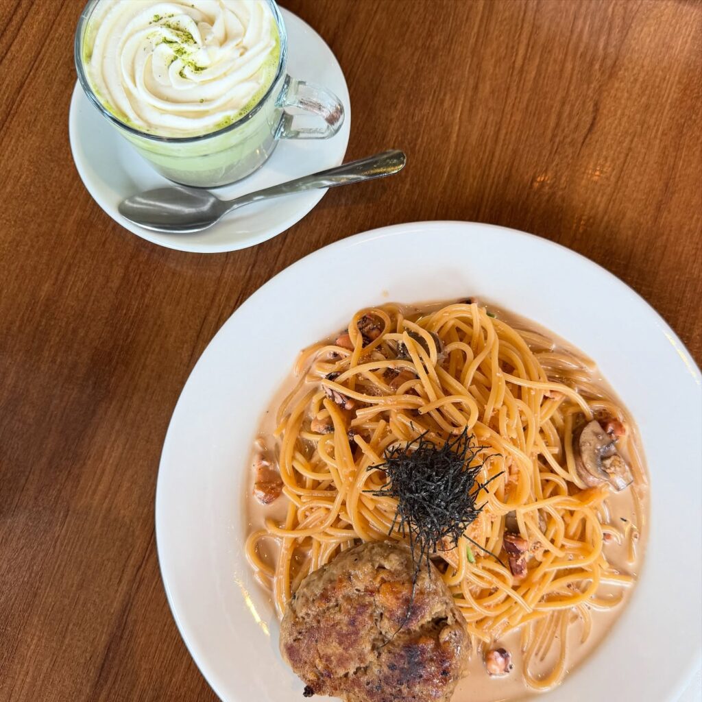 Cafe de l'Orangerie French Japanese Cafe Vancouver | Photo of green latte and spaghetti with cream sauce and hamburger steak on a white plate | Homes Almanac 