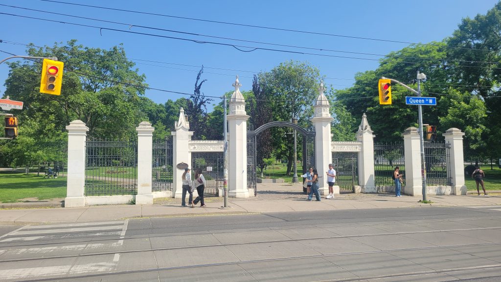 history of trinity bellwoods and ossington | A bright sunny day with the remaining white gates at the entrance of Trinity Bellwoods park | Homes Almanac