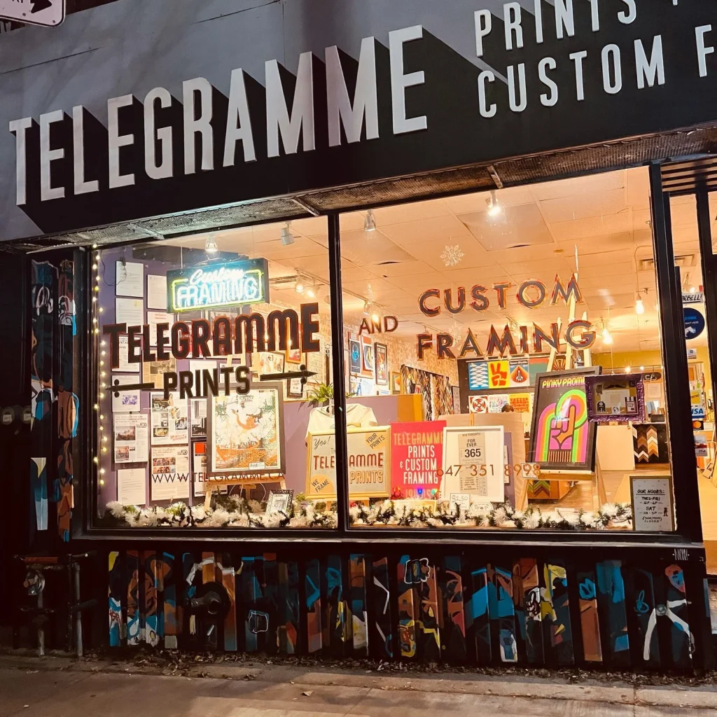 Telegramme Prints | Exterior shot of a print shop with brightly coloured prints sitting in a window and colourful graffiti on the building's exterior | Homes Almanac