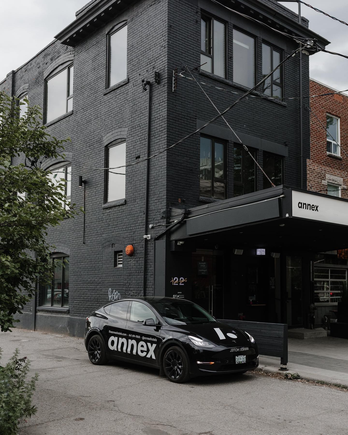 The Annex Hotel | Grey brick building with a black car parked out front | Homes Almanac