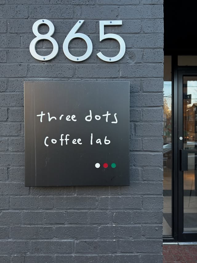 Three Dots Coffee Lab | Grey brick with "865" in silver hanging on the wall and a black square sign that says "three dots coffee lab" in white | Homes Almanac