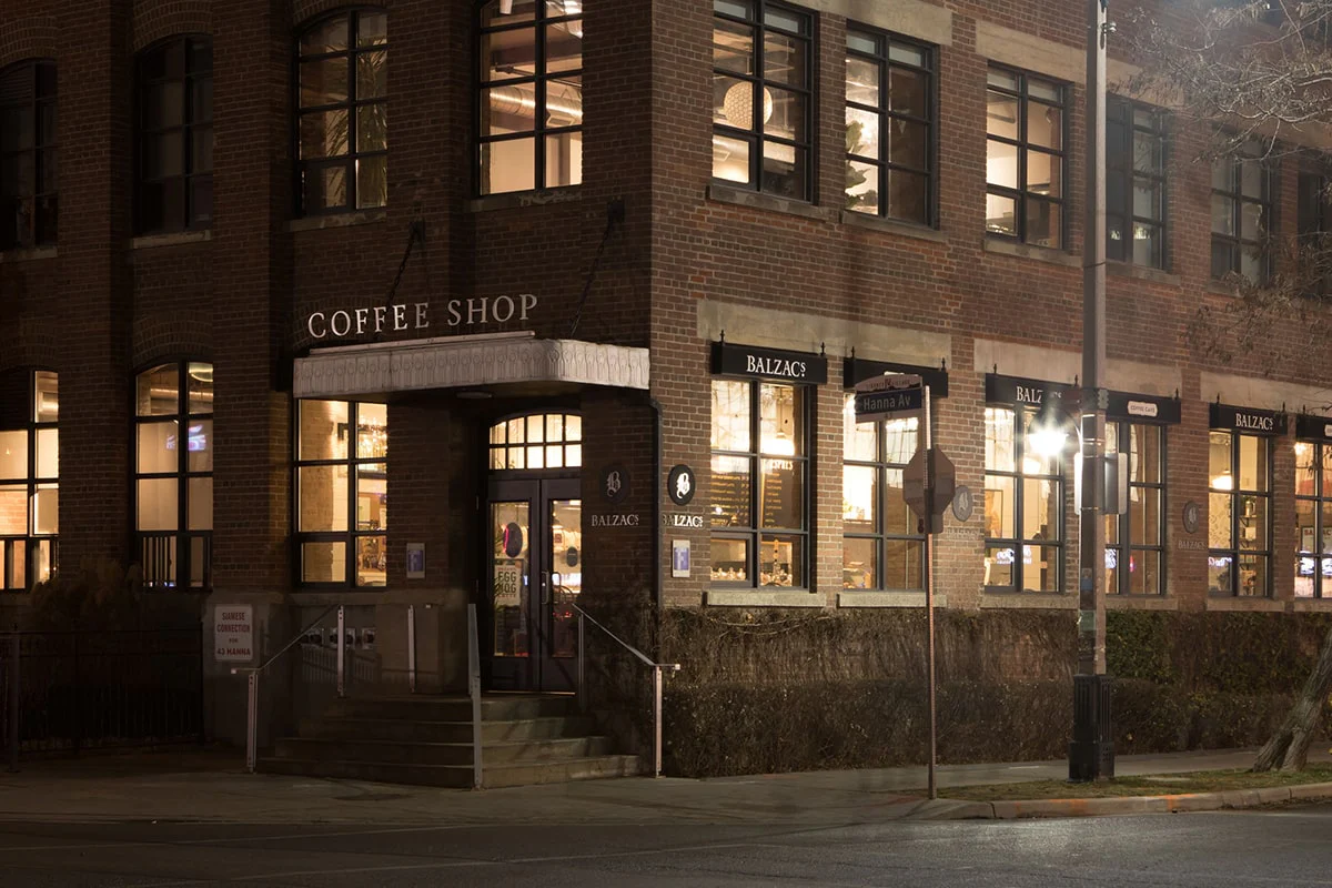 Work-friendly cafes Liberty Village | Early morning darkness with a brick building and windows with light shining through | Homes Almanac