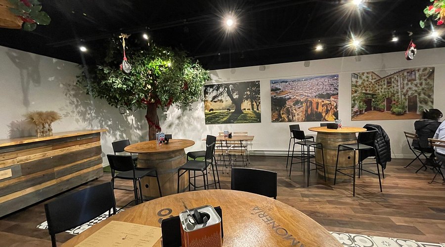 Jamoneria by Arc Imports | A room with wine barrel tables, black high tops and artificial tree in a corner | Homes Almanac