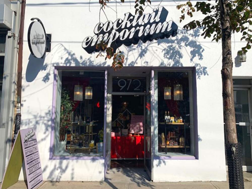 cocktail emporium on queen west | a white retail front with "cocktail emporium" in black and white, a door with windows on either side | Homes Almanac
