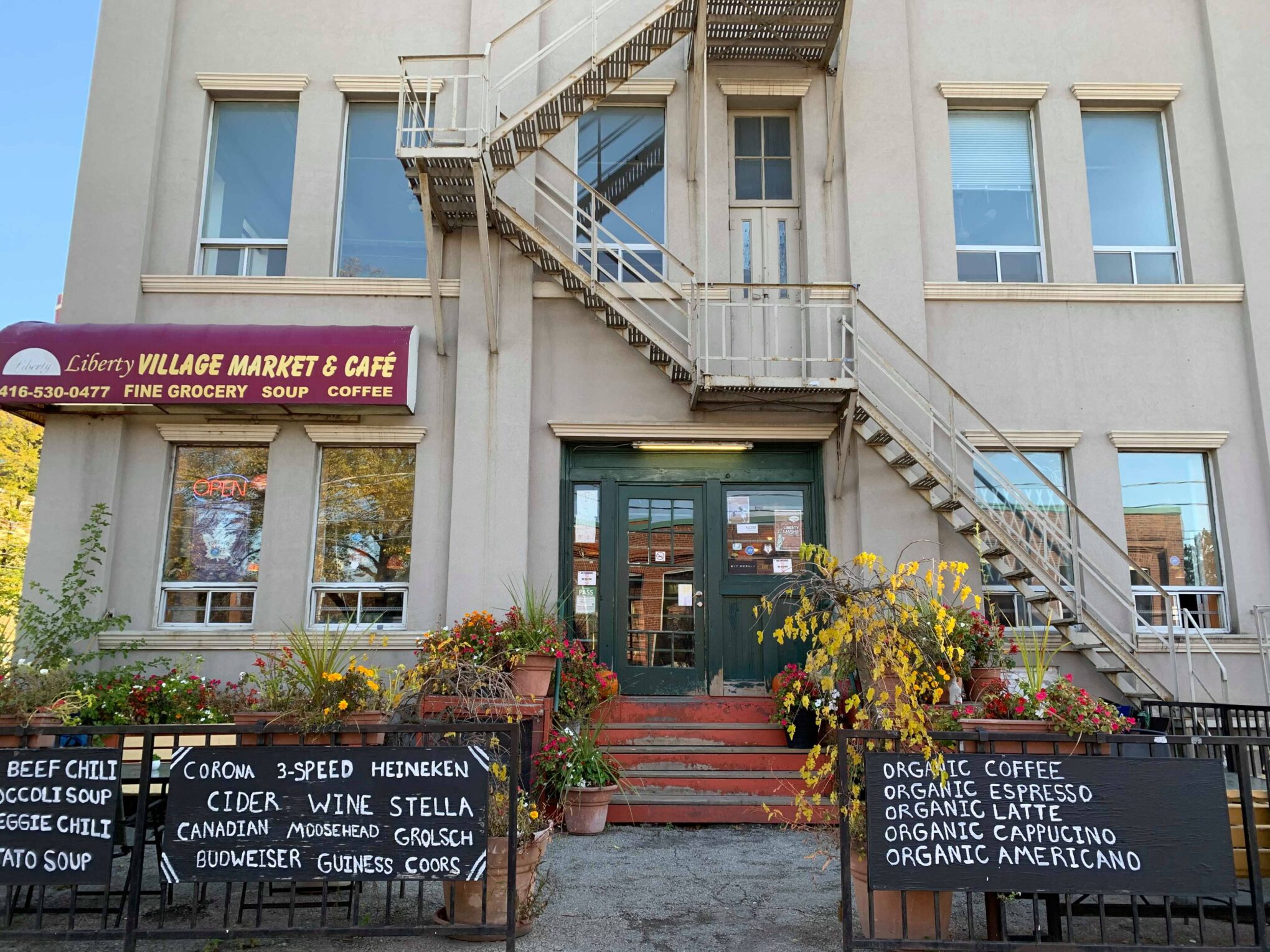 Liberty Village Market & Cafe | Exterior white brick building with green door | Homes Almanac
