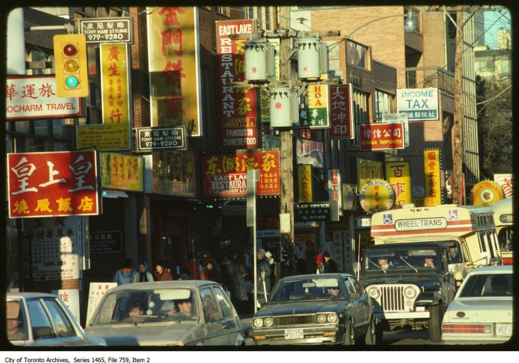 Toronto Chinatown History | Chinatown West with many signs mostly red or yellow with English and Chinese writing on the sides of buildings | Homes Almanac