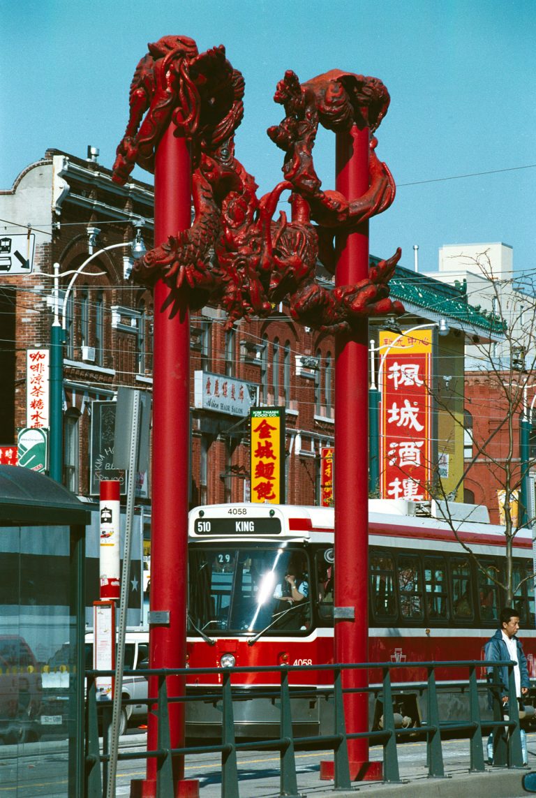 Toronto Chinatown History | Iconic red gates and red Toronto bus at the entrance of Chinatown | Homes Almanac