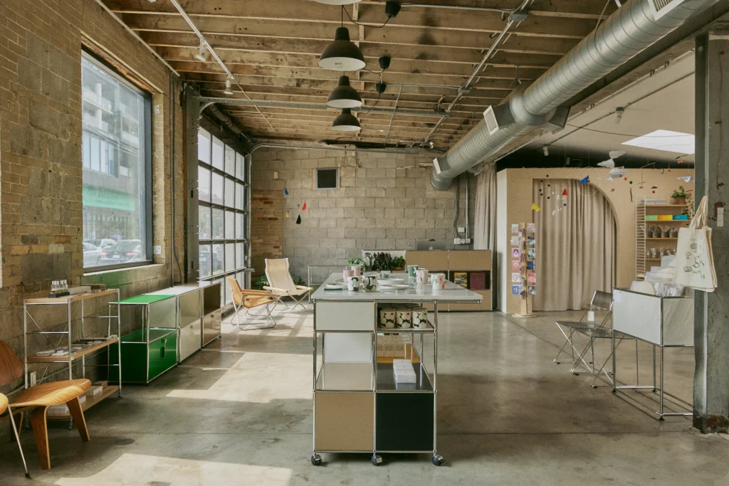 Home FortyFour | Concrete floor to ceiling show room with natural light coming in from large windows and minimalist furniture and home decor | Homes Almanac