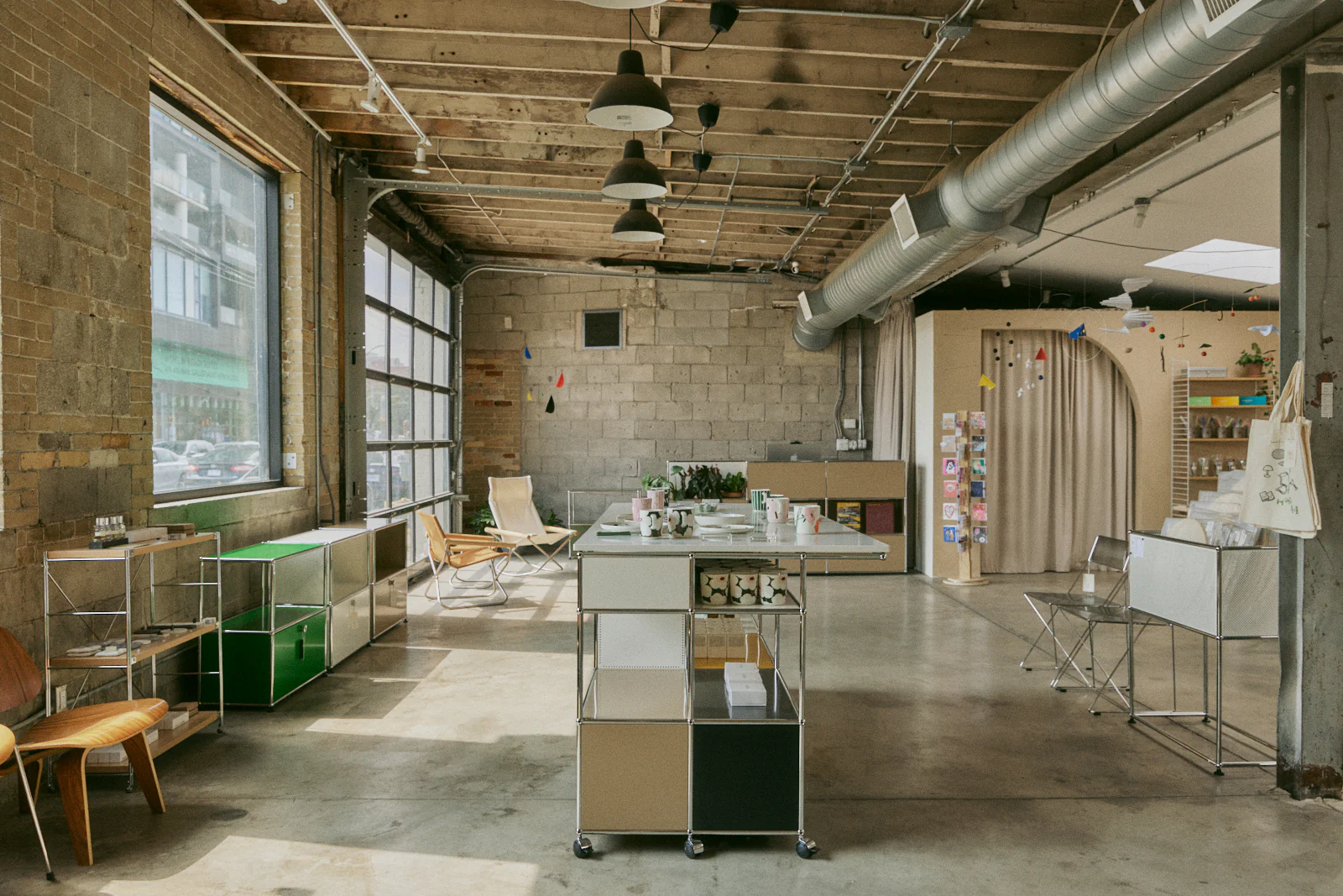 Home FortyFour | Concrete floor to ceiling show room with natural light coming in from large windows and minimalist furniture and home decor | Homes Almanac