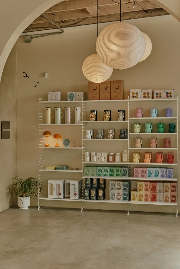 Toronto West End Home Goods | Dimly lit space with white walls and white shelving housing colourful home decor pieces | Homes Almanac