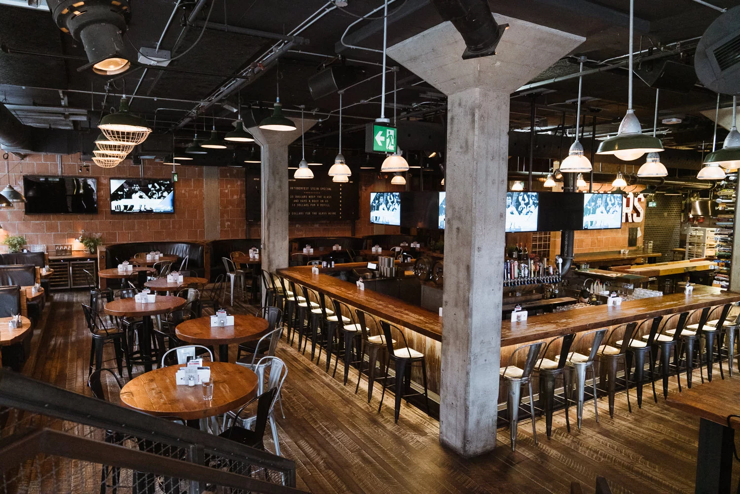 LOCAL Public Eatery Liberty Village | A sports bar with wooden high tops and bar and moody lighting | Homes Almanac