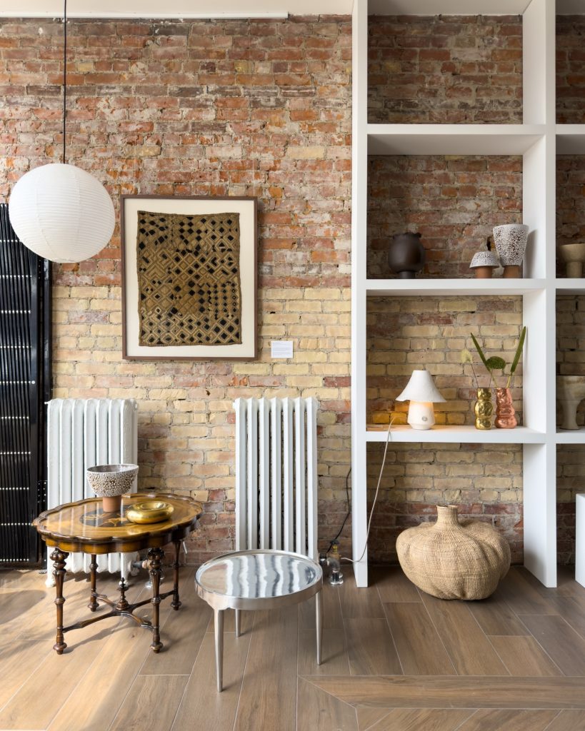 Toronto West End Home Decor | Naturally lit showroom with red brick wall and warm but minimal decor | Homes Almanac