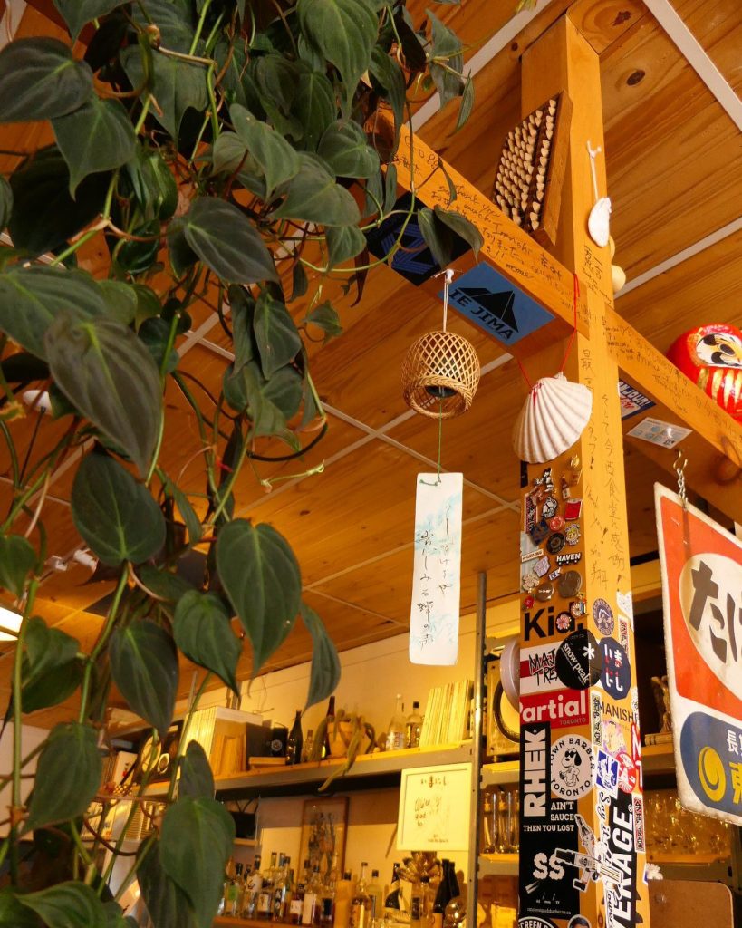 Japanese izakaya toronto | Wood beam and ceiling decorated in 1970s-era Japanese trinkets and stickers | Homes Almanac