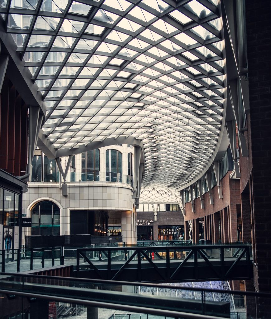 master-planned third places | Dramatic, moody shot on the 3rd floor showcasing glass ceiling and pedestrian foot bridges across three levels | Homes Almanac